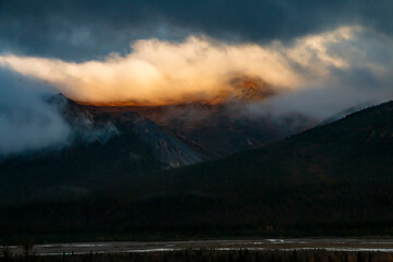 dramatic autumn landscape of snowcapped mountain ranges and peaks inside DEnali National park .