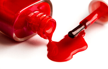 Open red nail polish bottle with brush