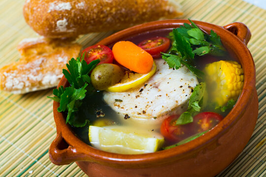 Recipe of pottage of fisherman: boil merluccius head for broth. Add potatoes, carrots, shallots, corn, fish steak 200 g, salt, pepper. Bring to oven, cook for 40min at temperature of 200 deg