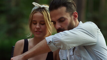 Handsome man putting french beans on grill. Couple spending time on grill party