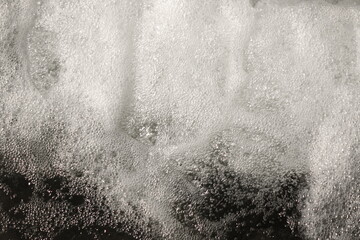 Foamed Water Top View With Bubbles Macro Shot. Water Foam Abstract Background Or Texture. Waves Surface Close Up Wallpaper. Splashes Water Foam.  SPA Water With Boiling Effect. Artificial Stream Water