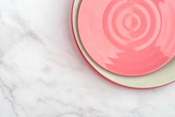 Fototapeta na wymiar Pink empty plates on a white marble table