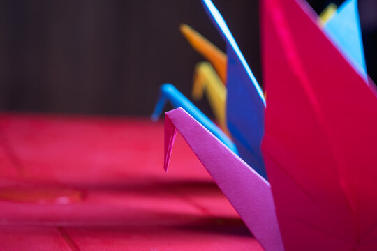 detail of colored cranes on a red plastic table