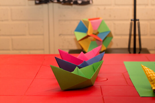 paper boats in origami on a red table
