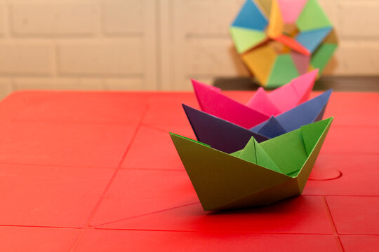 paper boats in origami on a red table
