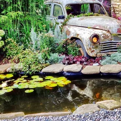 Poster de jardin  Modern Landscaped Backyard Garden with Small Artificial Pond from PVC and Old Car as Designed Element. Modern Garden at House with Stony Landscaping  Retro Style with Decorative Pond and Old Car.  © Alex