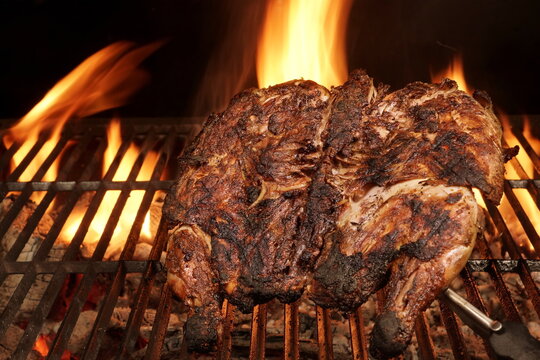 Whole Chicken Grilled On Hot Barbecue Charcoal Flaming Grill. Juicy Chicken Meat Roasted On BBQ Grill. Backyard Grill Party Dish From Poultry Isolated On Black Background, Closeup View.