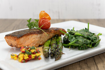 Grilled Salmon steak served with asparagus and spinach to indulge that seafood appetite