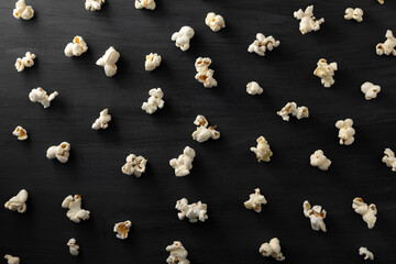 Palomitas de maíz alineadas en patrón sobre un fondo negro.