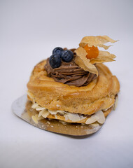 cake for breakfast with blueberries and chocolate cream on a light background