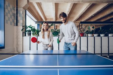Young people, man and woman playing table tennis