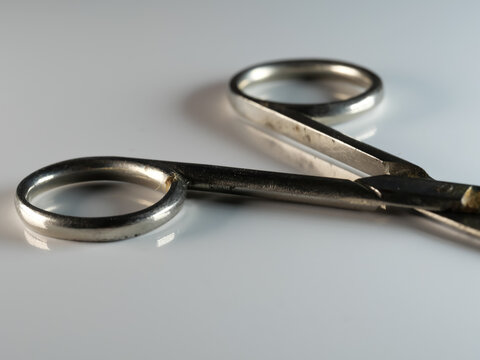 Closeup Of Nail Scissors On A Gray Surface With A Blurry Background