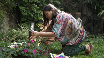 Woman picking herbs from her garden orchard