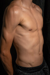 A young muscular model on dark background