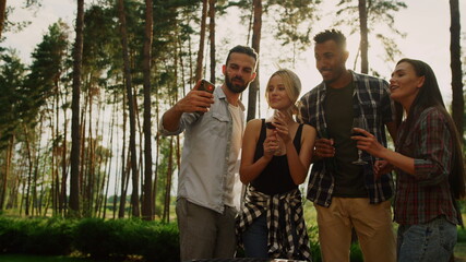 Fototapeta premium Smiling people making selfie on mobile on backyard. Guys having fun outdoors