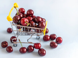 Fresh cherries in shopping wheel basket.