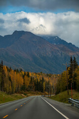 autumn road trip to the open roads of Alaska along the  snow capped mountains and vibrant golden yellow foliage of autumn.