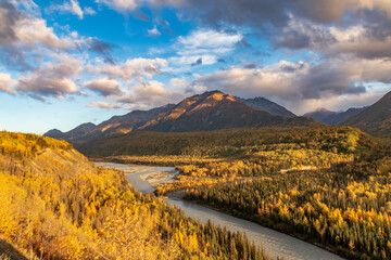 dramatic landscape of autumn foliage in the Matanuska River and snow capped mountains of the...