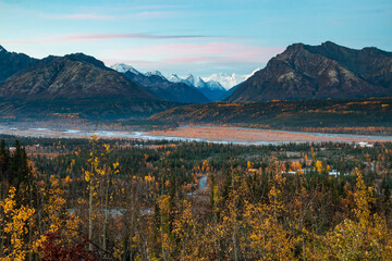 dramatic landscape of autumn foliage in the Matanuska River and snow capped mountains of the Chugach mountain range in Alaska