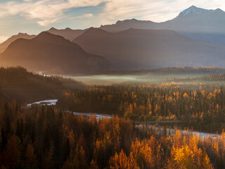 Fototapeta na wymiar dramatic landscape of autumn foliage in the Matanuska River and snow capped mountains of the Chugach mountain range in Alaska