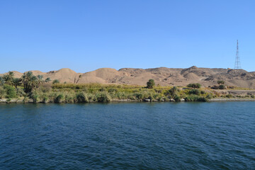 A wonderful view of the Nile River and palm trees, and in the background is a desert from southern Egypt
