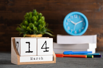 March 14th. March 14 wooden cube calendar with blur objects on background.