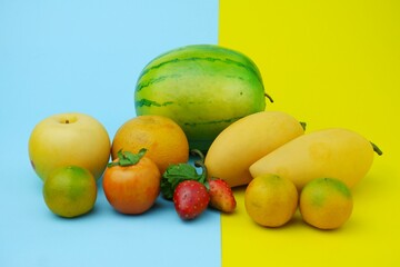 Plastic fruit on blue background with yellow color. Fake fruit, fruit model.