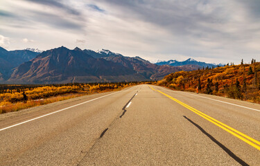 autumn road trip to the open roads of Alaska along the  snow capped mountains and vibrant golden yellow foliage of autumn.