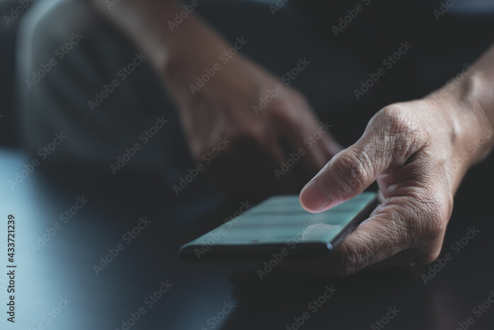 Aufkleber man hand using mobile phone, finger touching on screen with dark background