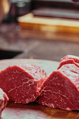 sliced raw beef tenderloin. fresh raw beef tenderloin on a wooden cutting board. 