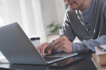 Casual business man online working on laptop computer from home office