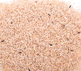 Pile of brown rice isolated on white background. Closeup.