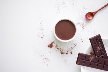 Chocolate milk in white cup with bar chocolate in whit plate on white background. coco hot drink in...