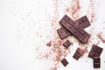 Bar Chocolate with powder chocolate on white background.  World Chocolate Day and snack or breakfast concept. flat lay or top view with copy space.