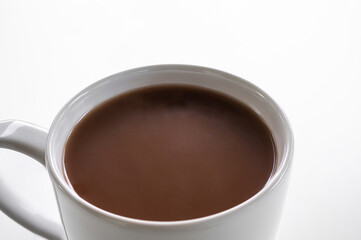 Chocolate milk close up in white cup on white background. coco hot drink in the morning for health. World Chocolate Day and snack or breakfast concept.