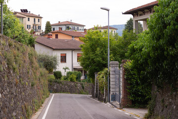 A street in the medieval town of Barga. Old houses in a thousand-year-old city. Spring in an Italian town in Tuscany. Old houses along the road with retaining walls.