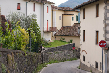 A street in the medieval town of Barga. Old houses in a thousand-year-old city. Spring in an Italian town in Tuscany. Old houses along the road with retaining walls.