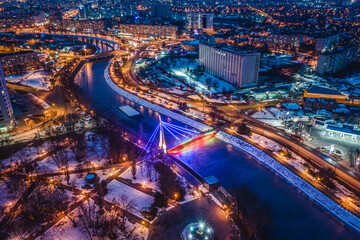 Bridge across river in illuminated park Strelka in Kharkiv