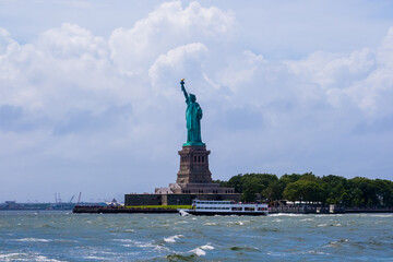 Fototapeta premium Beautiful view of the Statue of Liberty on blue sky background , the Hudson River and the skyscrapers of Manhattan, New York ,USA
