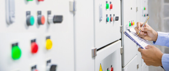 Electricity and electrical maintenance service, Engineer checking air handling unit AHU starter button control panel and hvac system of air conditioner load center cabinet for maintenance.
