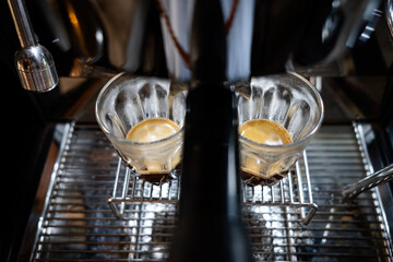 Fresh espresso shot pouring out of machine.