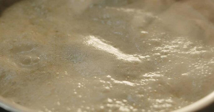 Hot coconut and banana sauce simmer and froth in a hot skillet