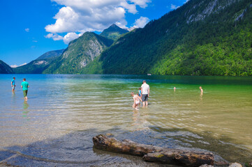 The view of Königssee lakeside. Germany. People playing in the lake.