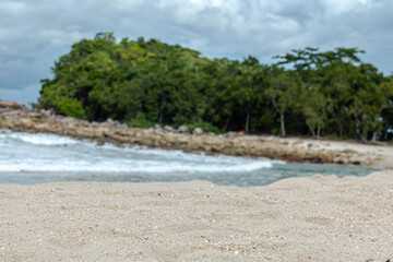 beach sand in focus, beach and forest background