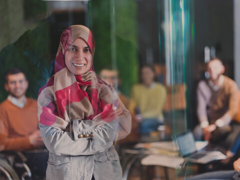 Muslim Woman Wearing Hijab In Office, Arabic Business Woman Covered With Headscarf Smiling. Successful Arab Businesswoman In Modern Office.