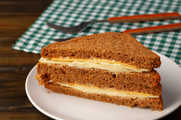 Double club sandwich served on plate on wooden table