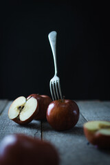 group of delicious red apples on rustic wood and a fork