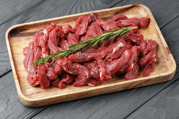 Raw sliced beef meat on wooden board