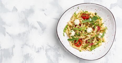 vegetarian salad, vegetable pasta Caprese salad with cherry tomatoes and mozzarella cheese. Long banner format, top view