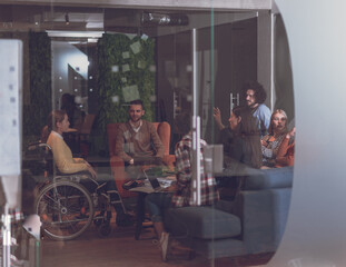 Businesswoman in wheelchair having business meeting with team at modern office 